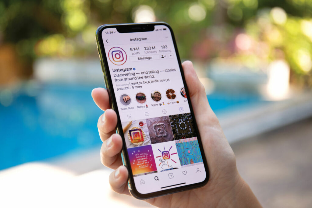 photo : Woman hand holding iPhone X with social networking service Instagram