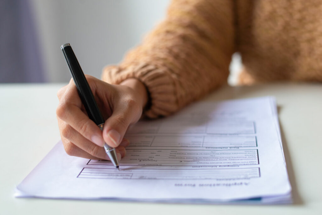 photo : Close-up of lady filling application form