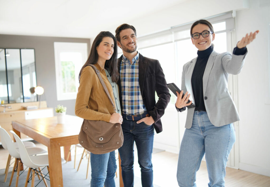 photo : Real estate agent showing modern house to attractive couple