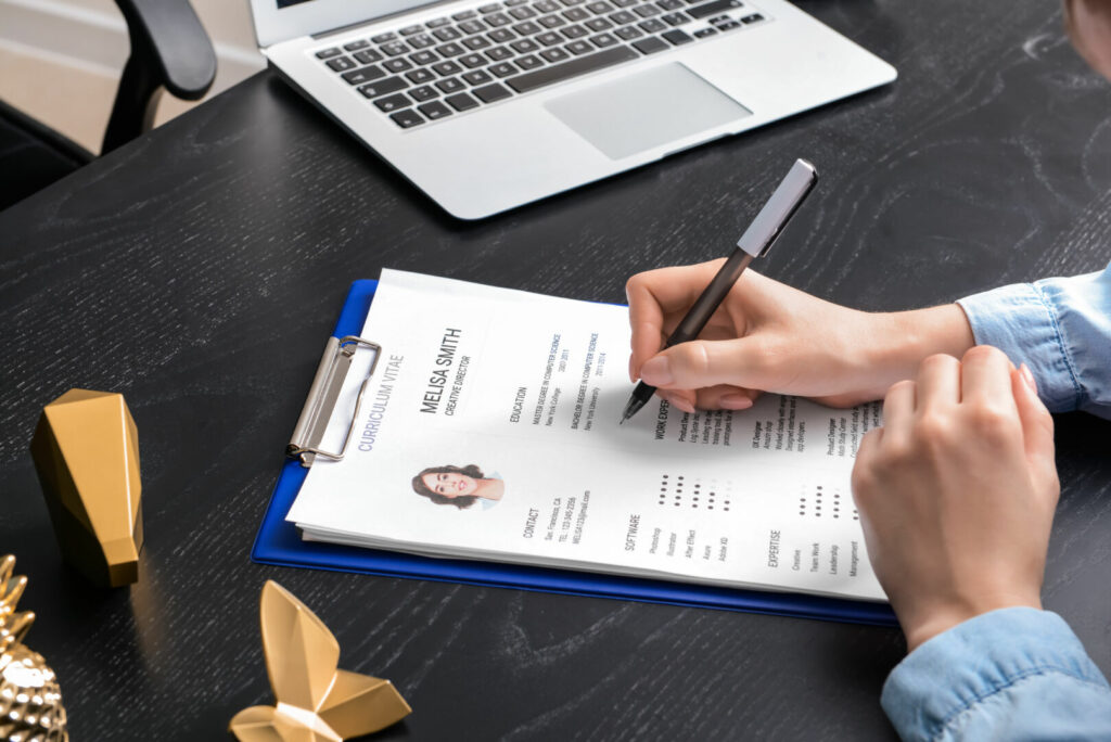 photo : HR manager studying job resume of candidate at table