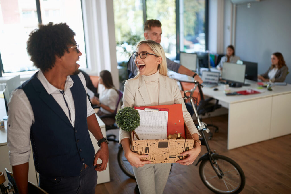 photo : Woman employee with personal stuff and colleagues at office