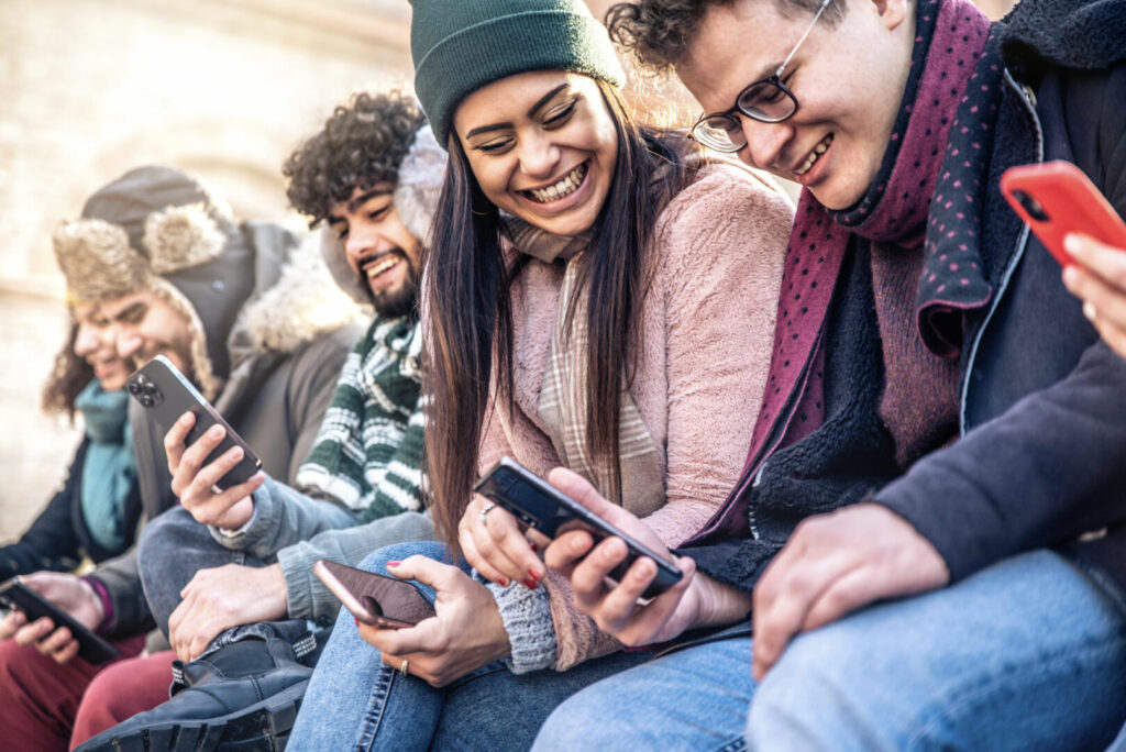 photo : Teenagers group watching smart phones mobile outdoors - Diverse