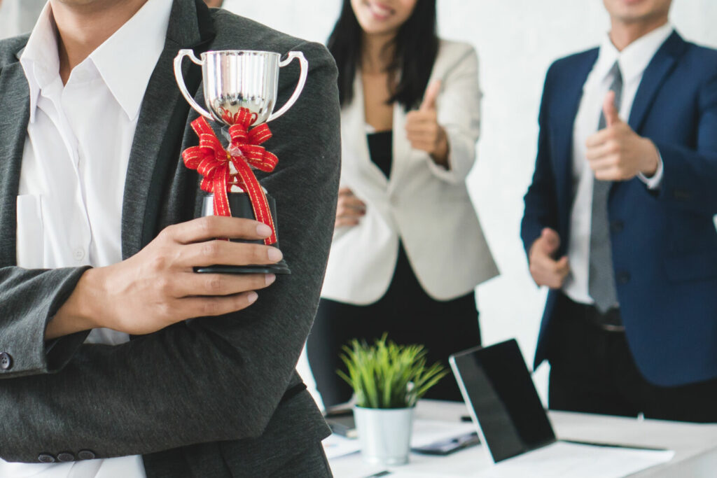photo : Worker holding trophy prize for best employees of the month in h