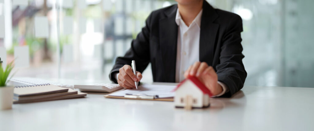 photo : Business woman working doing finances and calculation cost of real estate investment while be signing to contract, Concept mortgage loan approval.