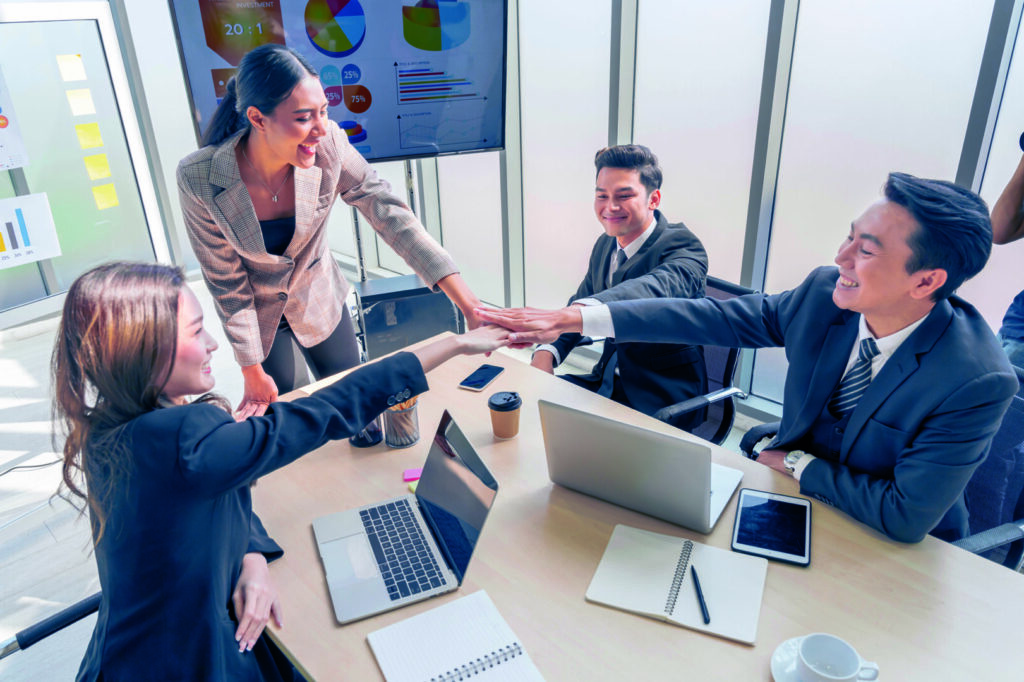 photo : Asian business team show unity with their hands in the office me