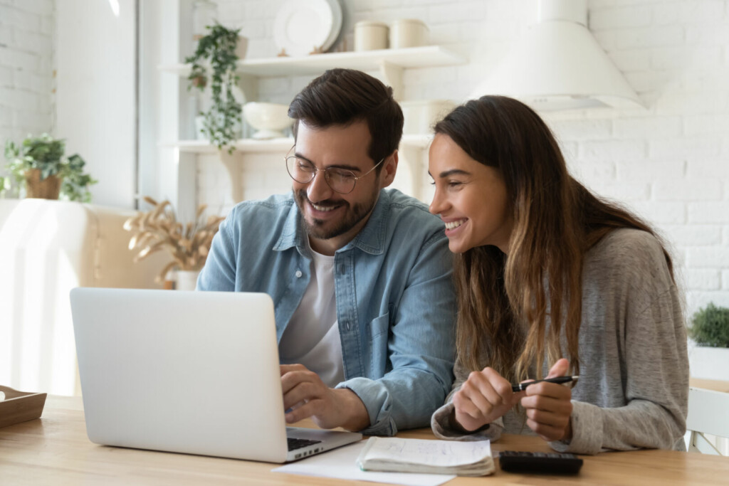 photo : Happy young couple paying bills online in computer app