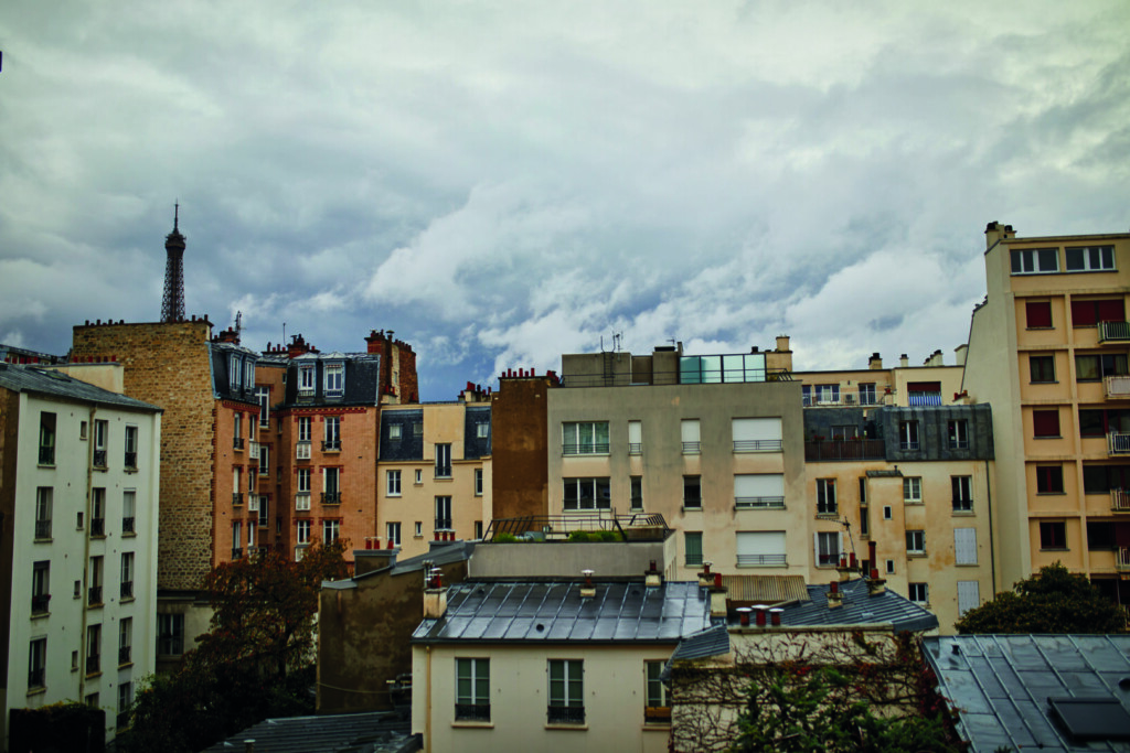 photo : View of the Eiffel tower with dramatic cloudscape over the roofs of residential buildings in Paris