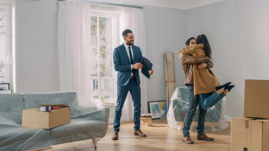photo : Real Estate Agent Shows Bright New Apartment to a Young Couple.
